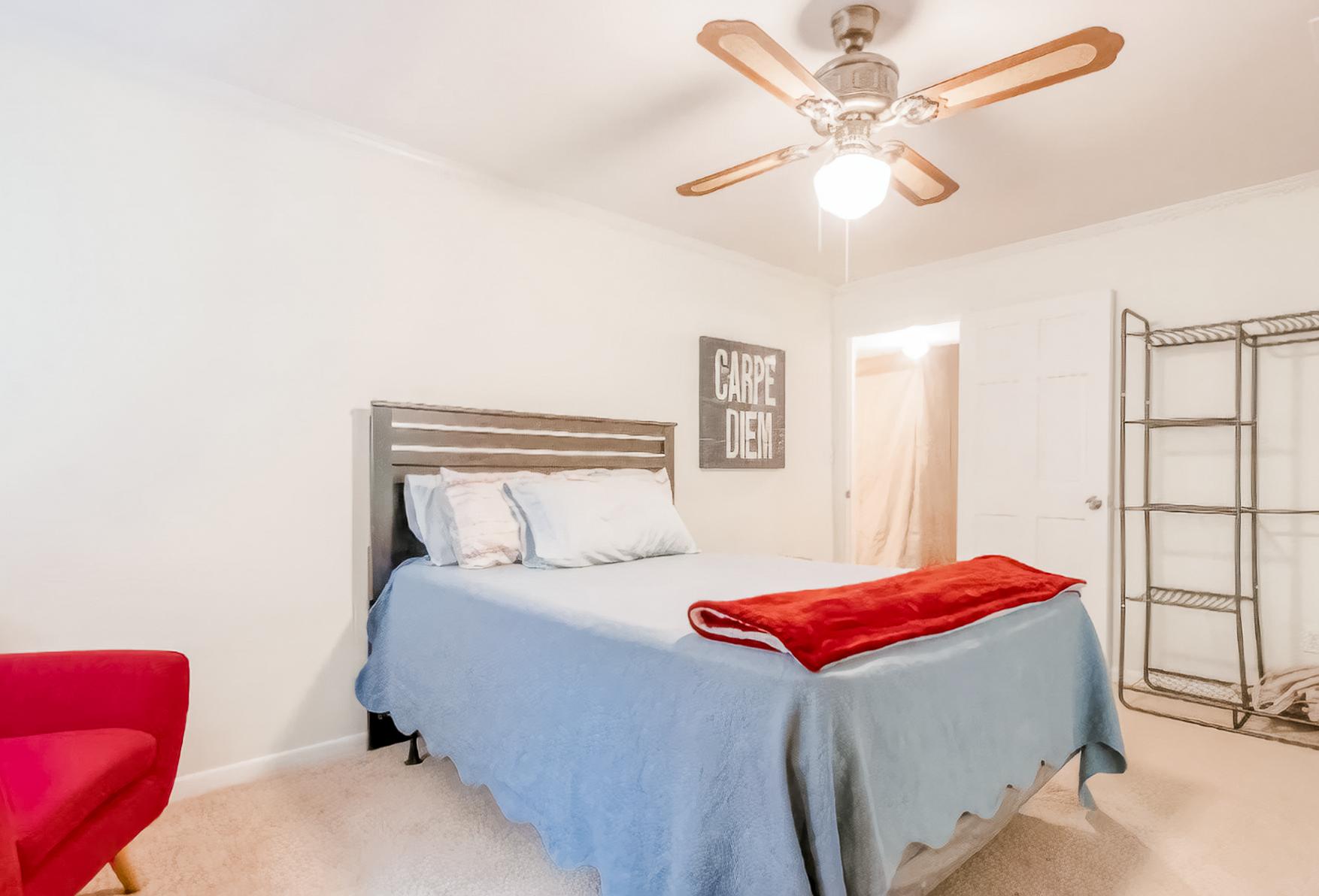Queen bed, dressor /mirror, and open clothes rack, chair and nice tile floor