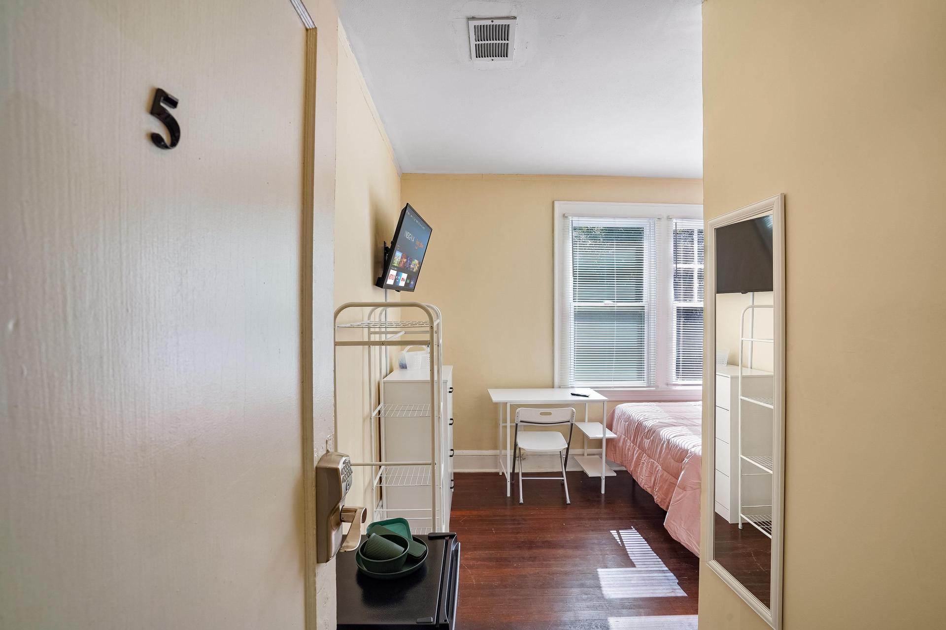 Room 5 comes with a walk in closet, TV, mini fridge, desk, chair, dresser, cubbies, and bed with linens included