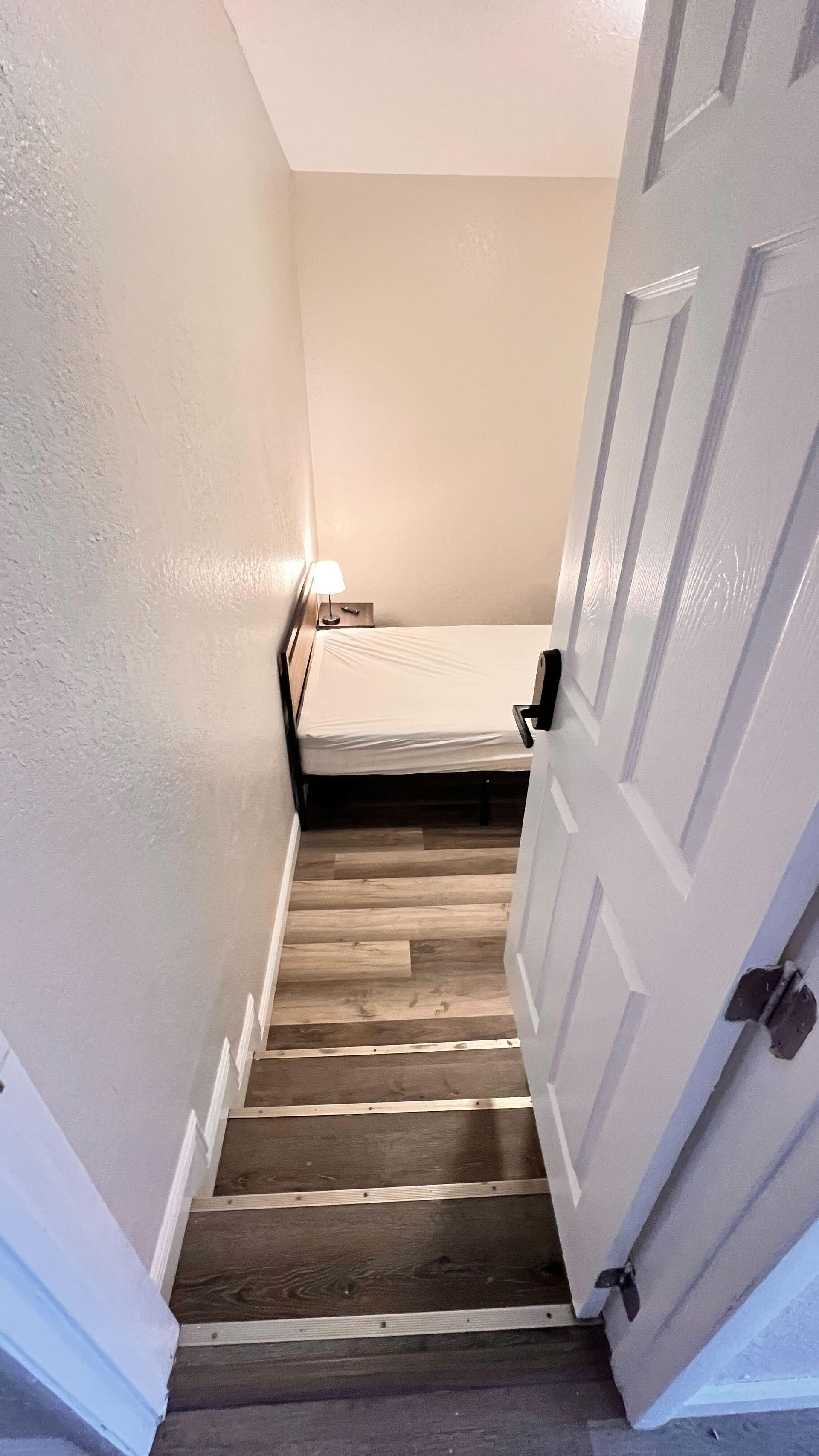 Furnished room near entrance and common area with work desk and relaxing space. Shared bath and on-site parking available.