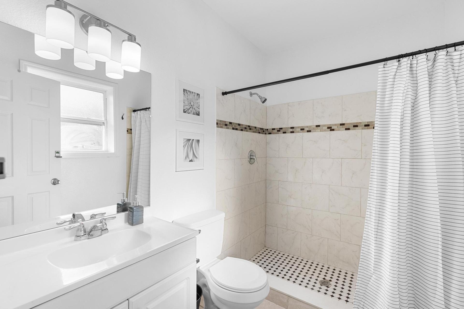 Clean shared bath with tiled shower & storage — freshly updated, Sanford, FL