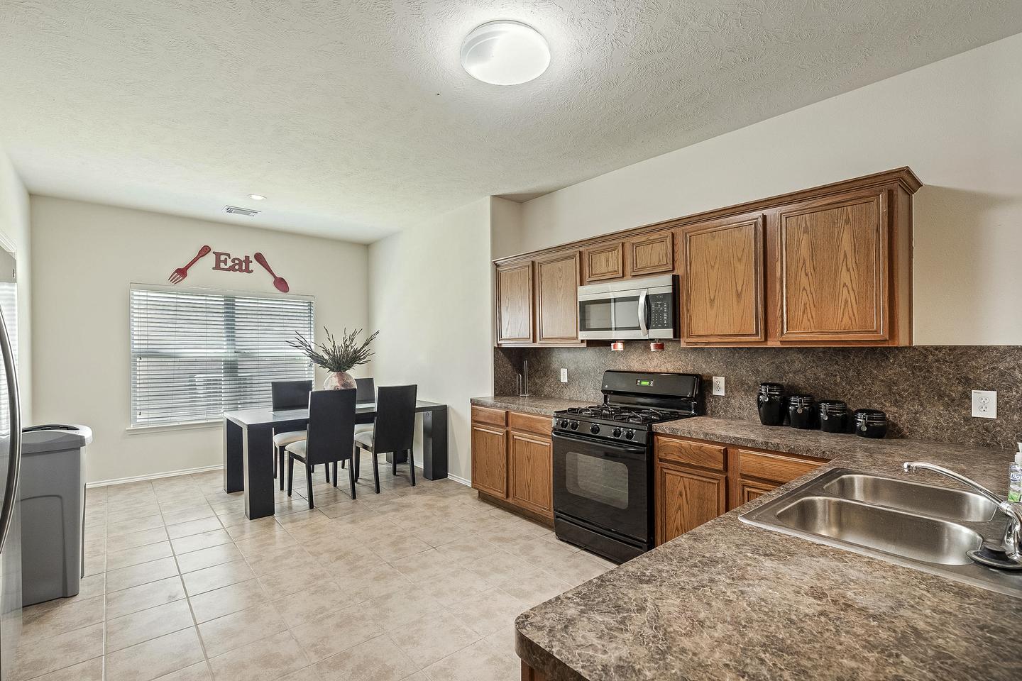 Enjoy some grub in this gorgeous and spacious open concept kitchen with gas stove and stainless steel refrigerator!