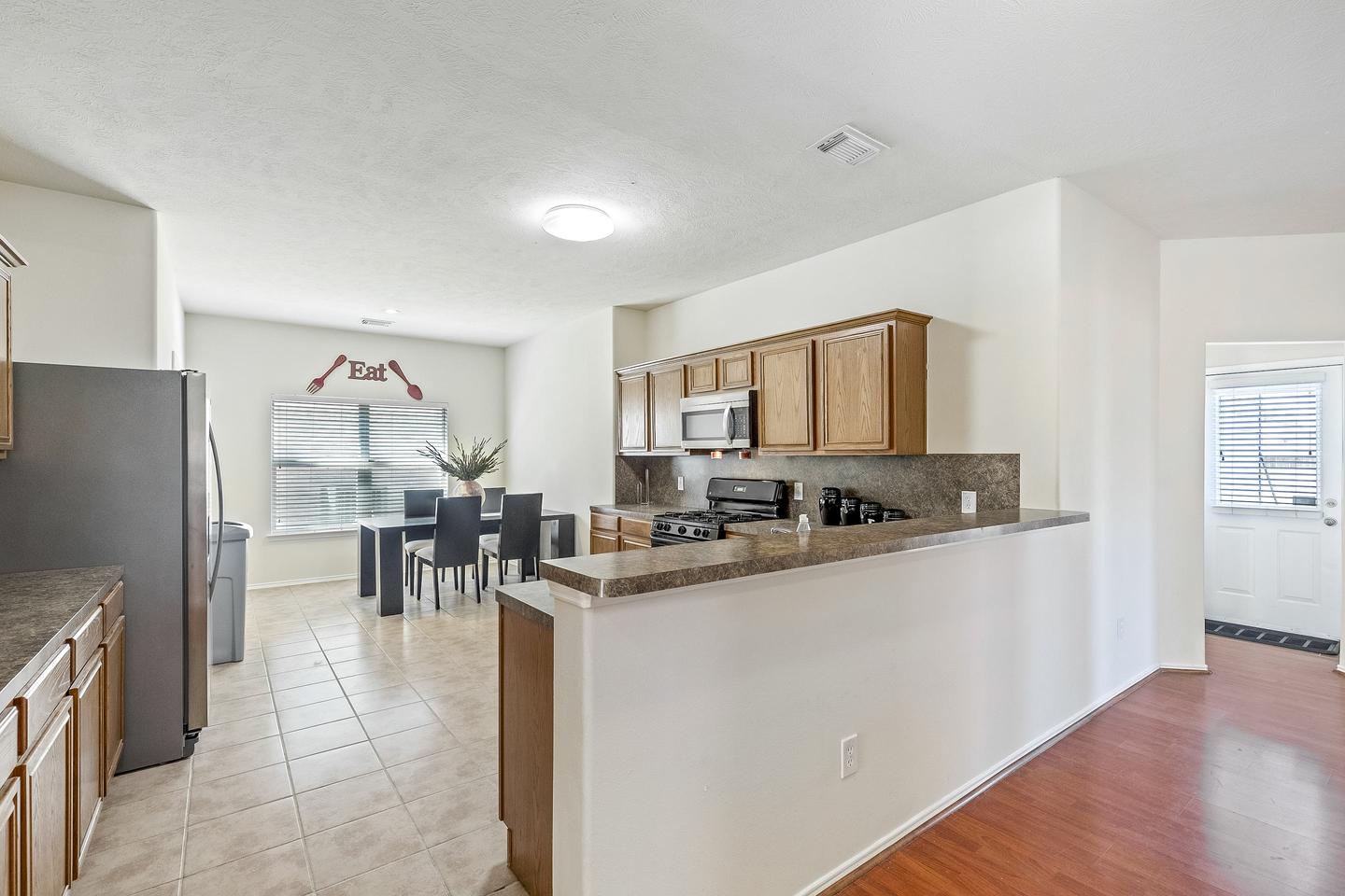 Enjoy some grub in this gorgeous and spacious open concept kitchen with gas stove and stainless steel refrigerator!