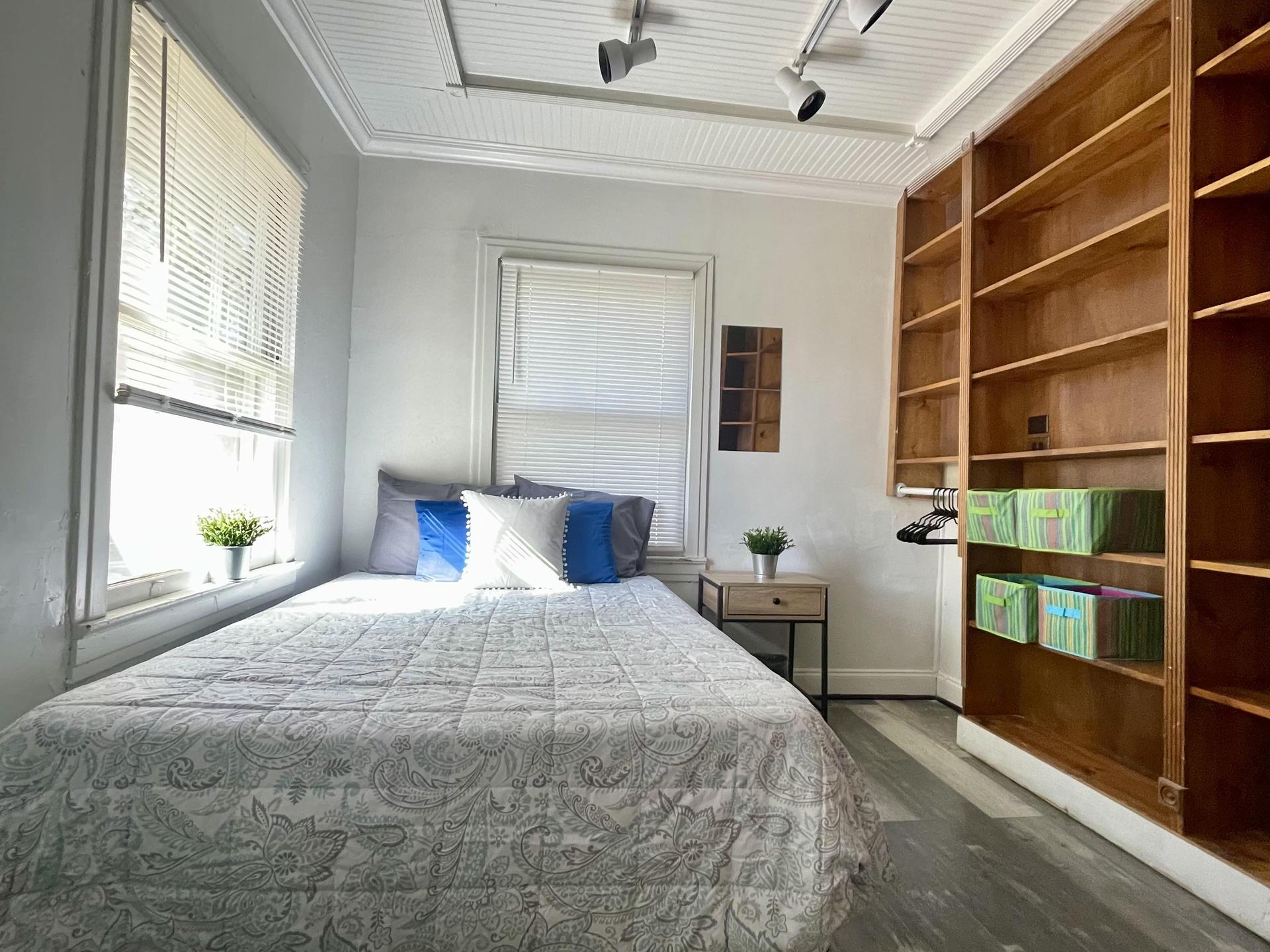 This bedroom has custom wood shelving which is amazing for organization! Great natural light.