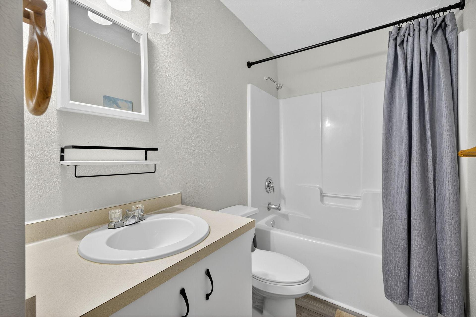 Bathroom B features a shower/tub combo, toilet, sink and linen closet with shelving dedicated for each bedroom