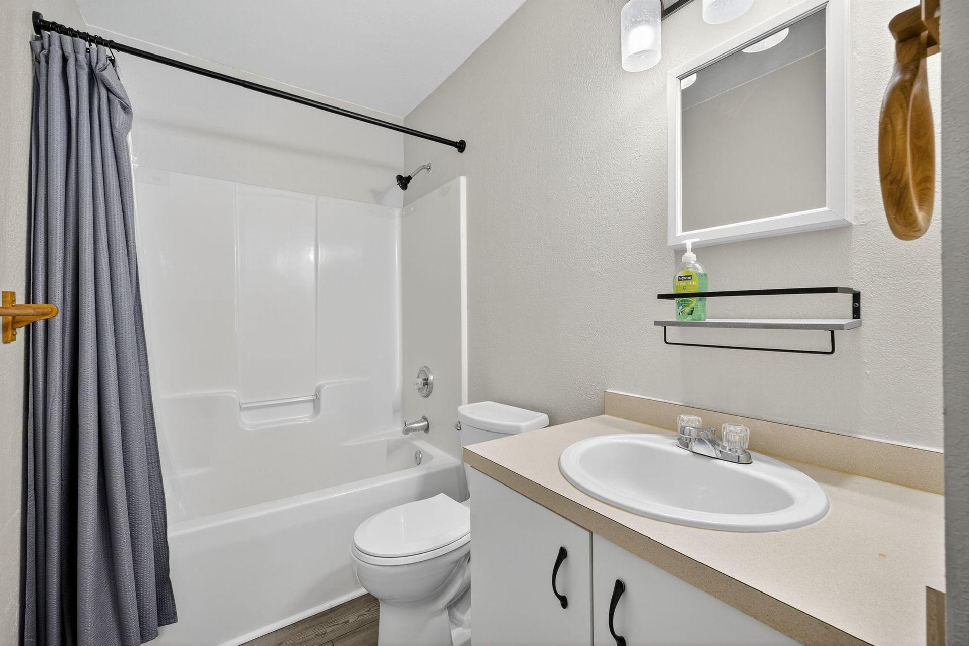 Bathroom A features a shower/tub combo, toilet, sink and linen closet with shelving dedicated for each bedroom