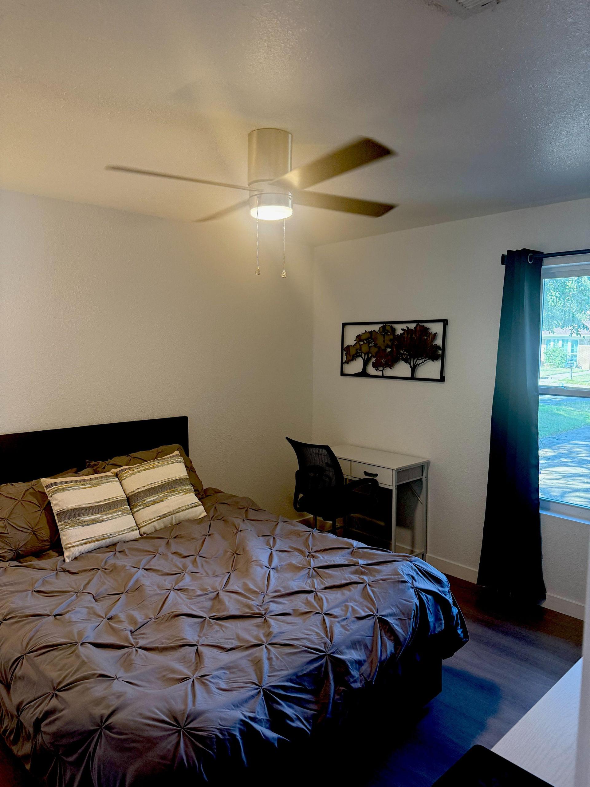 Queen bed and desk with window to front