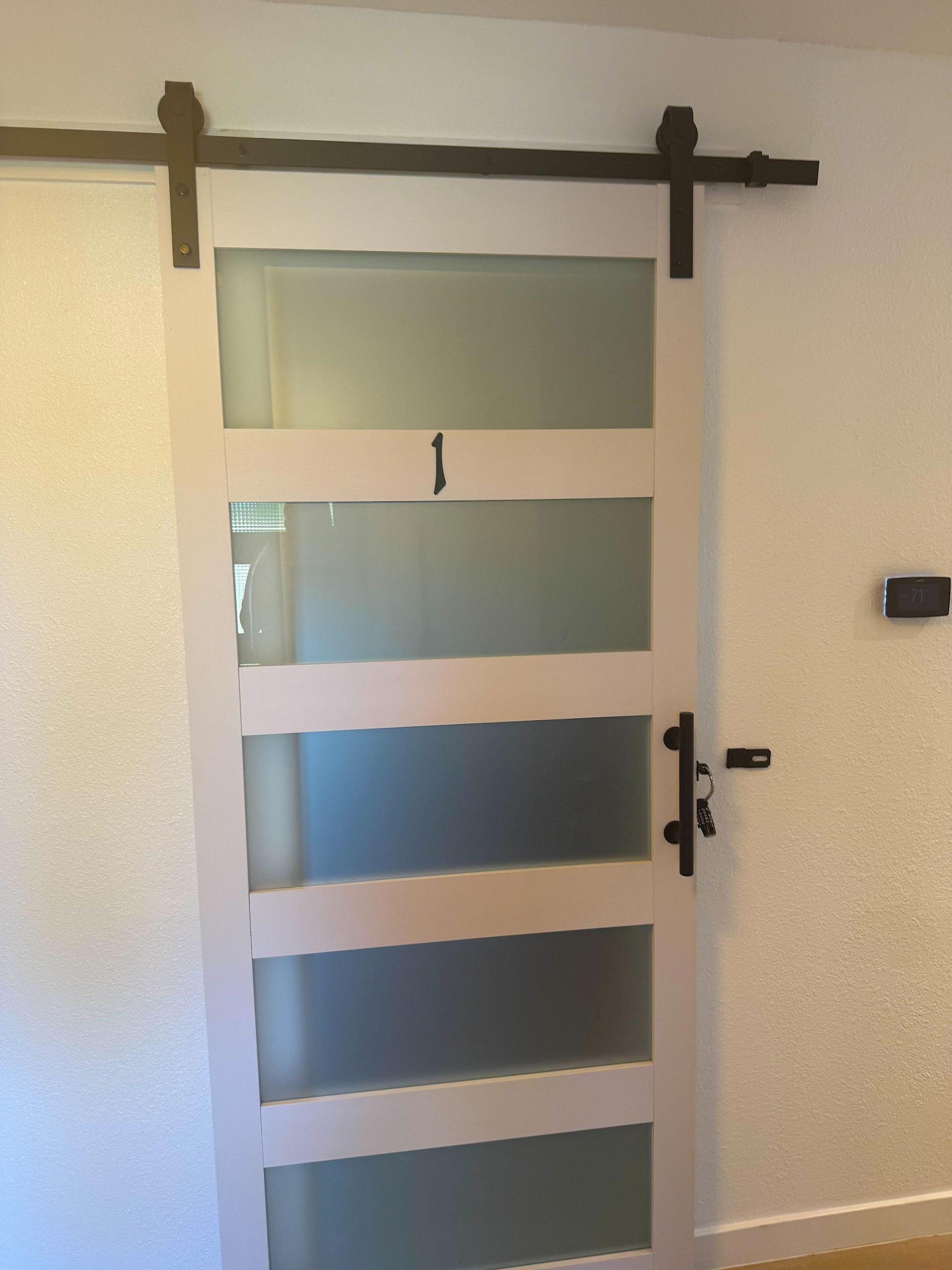 Sliding barn door with interior latch and exterior padlock