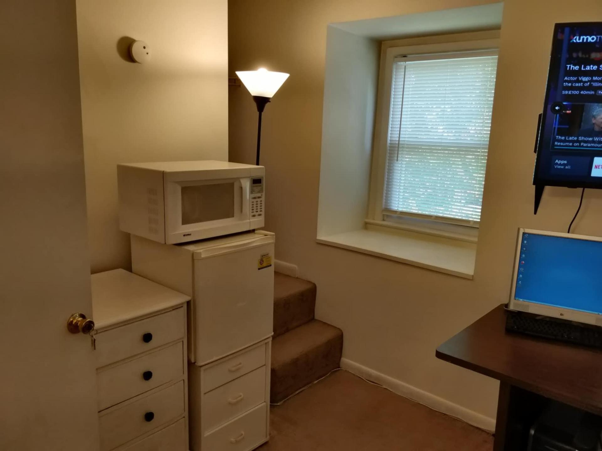 In-room minifridge, microwave, and closet entrance.