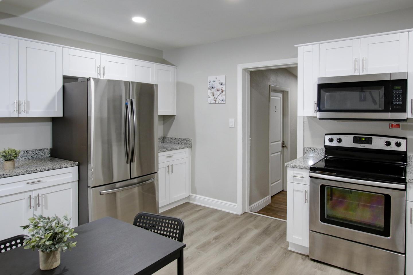 Updated eat-in kitchen with stainless steel refrigerator, oven, microwave and plenty of cabinet space for kitchen storage.