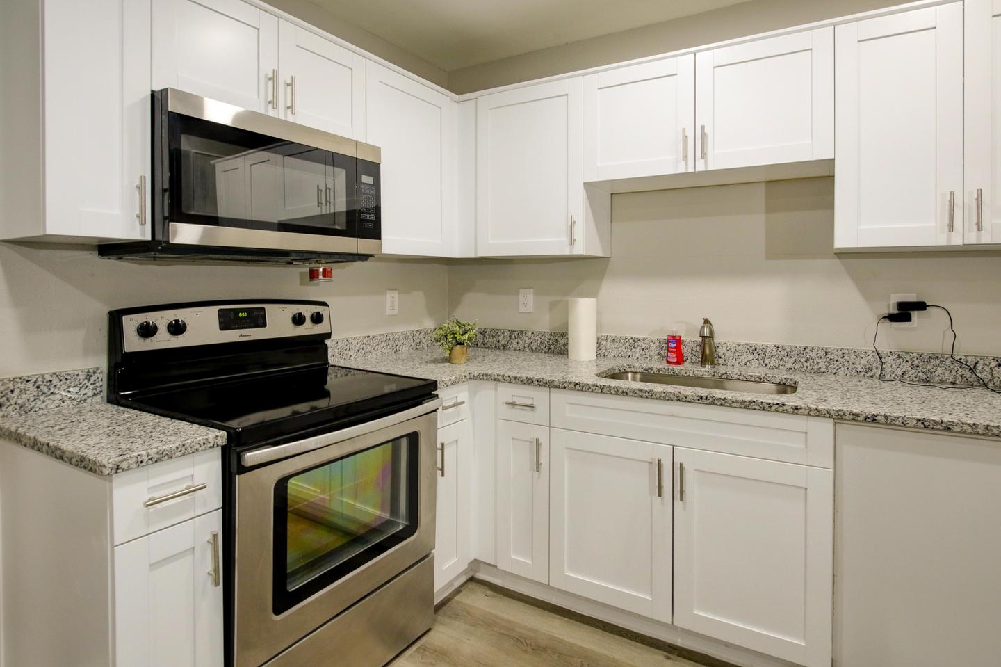 Updated eat-in kitchen with stainless steel refrigerator, oven, microwave and plenty of cabinet space for kitchen storage.