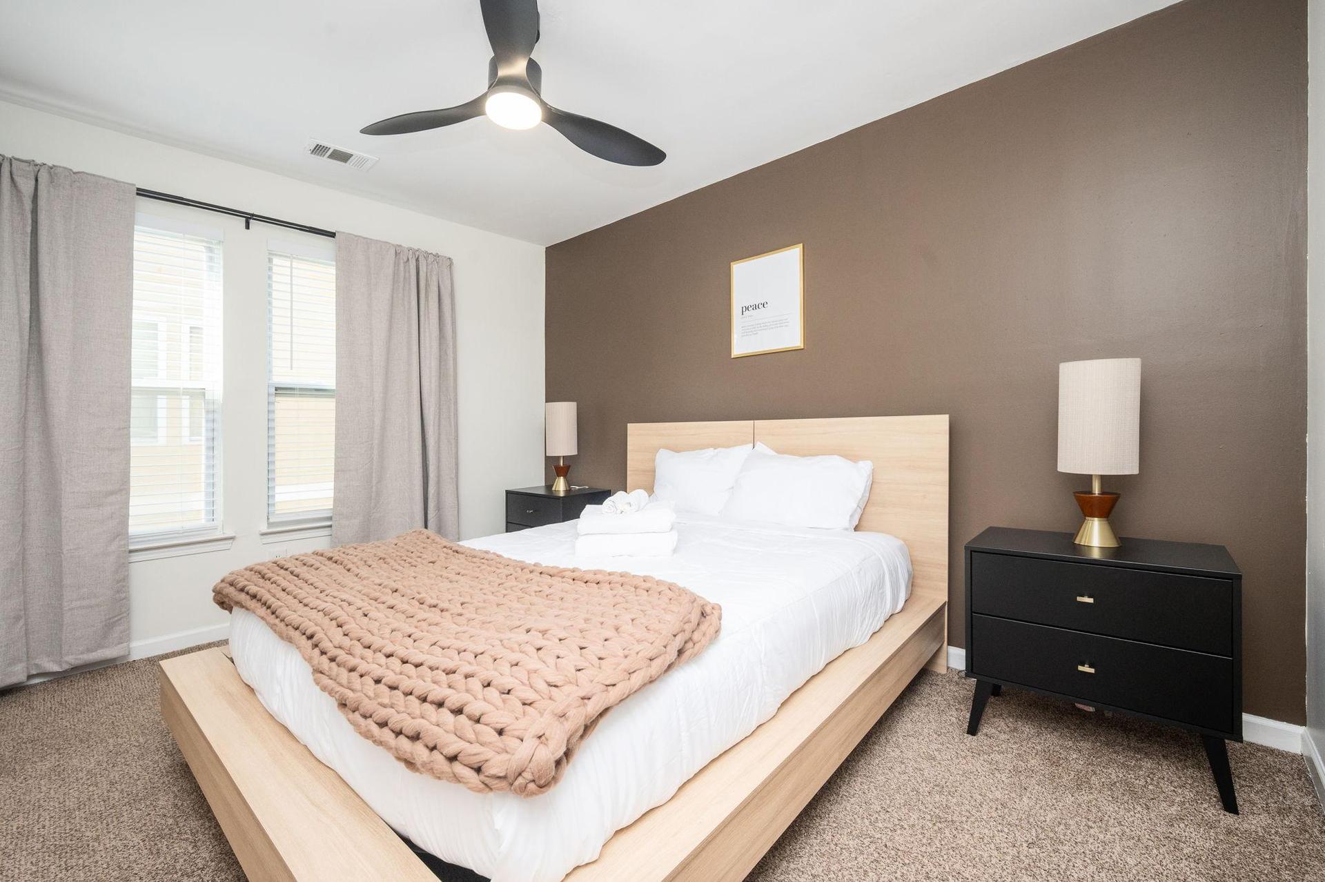 Private room with Queen sized bed, ceiling light, fan, walk-in closet and bedside nightstands