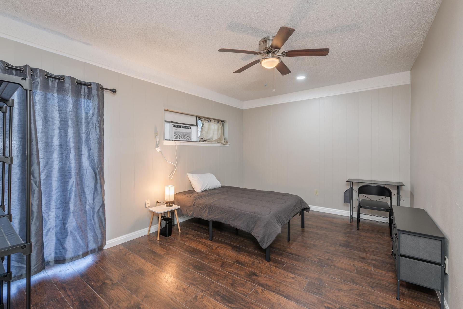 Room equipped with a full sized bed, dresser, wardrobe, trashcan, desk/chair, night stand and night light.