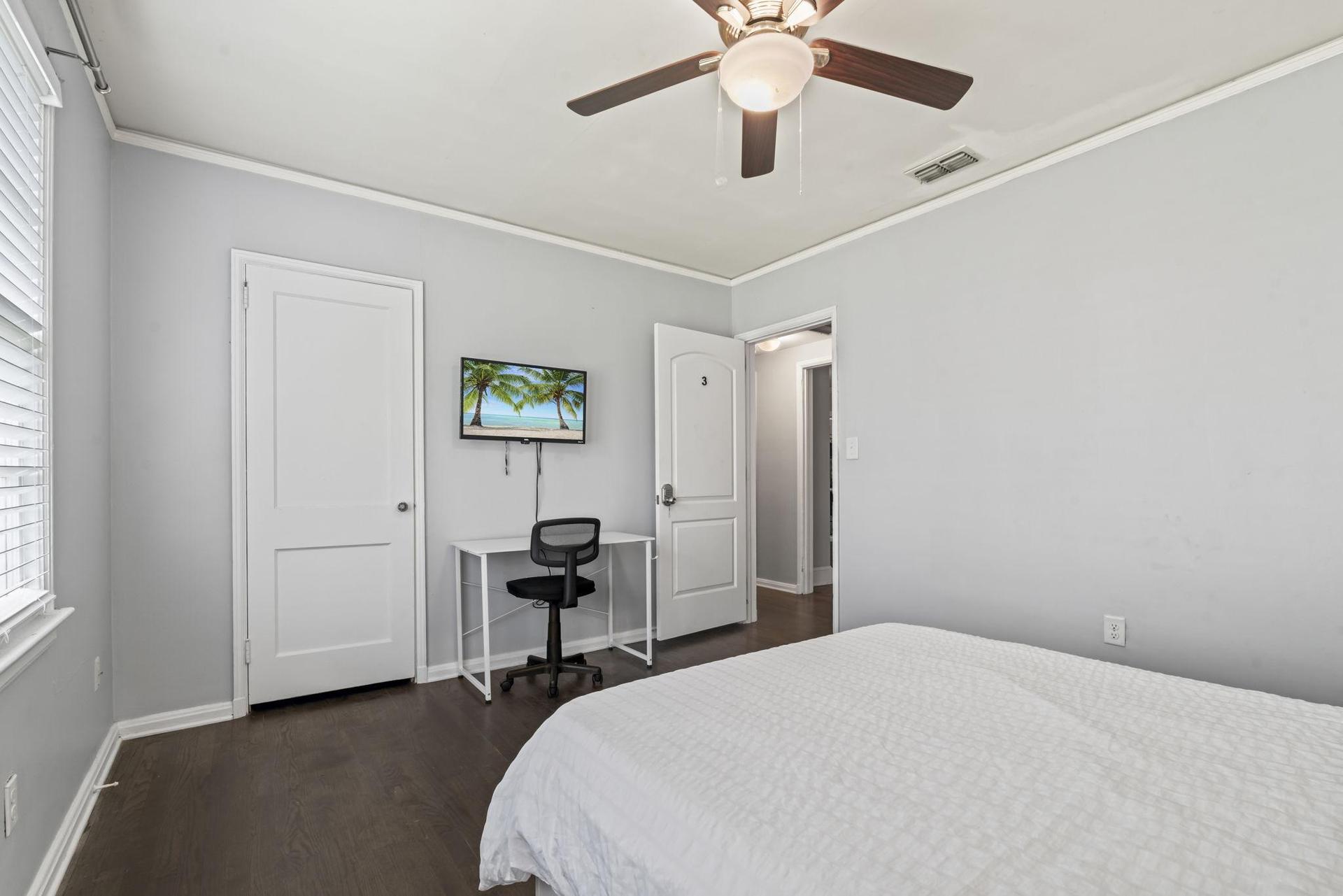 This room includes TV, workspace and ceiling fan