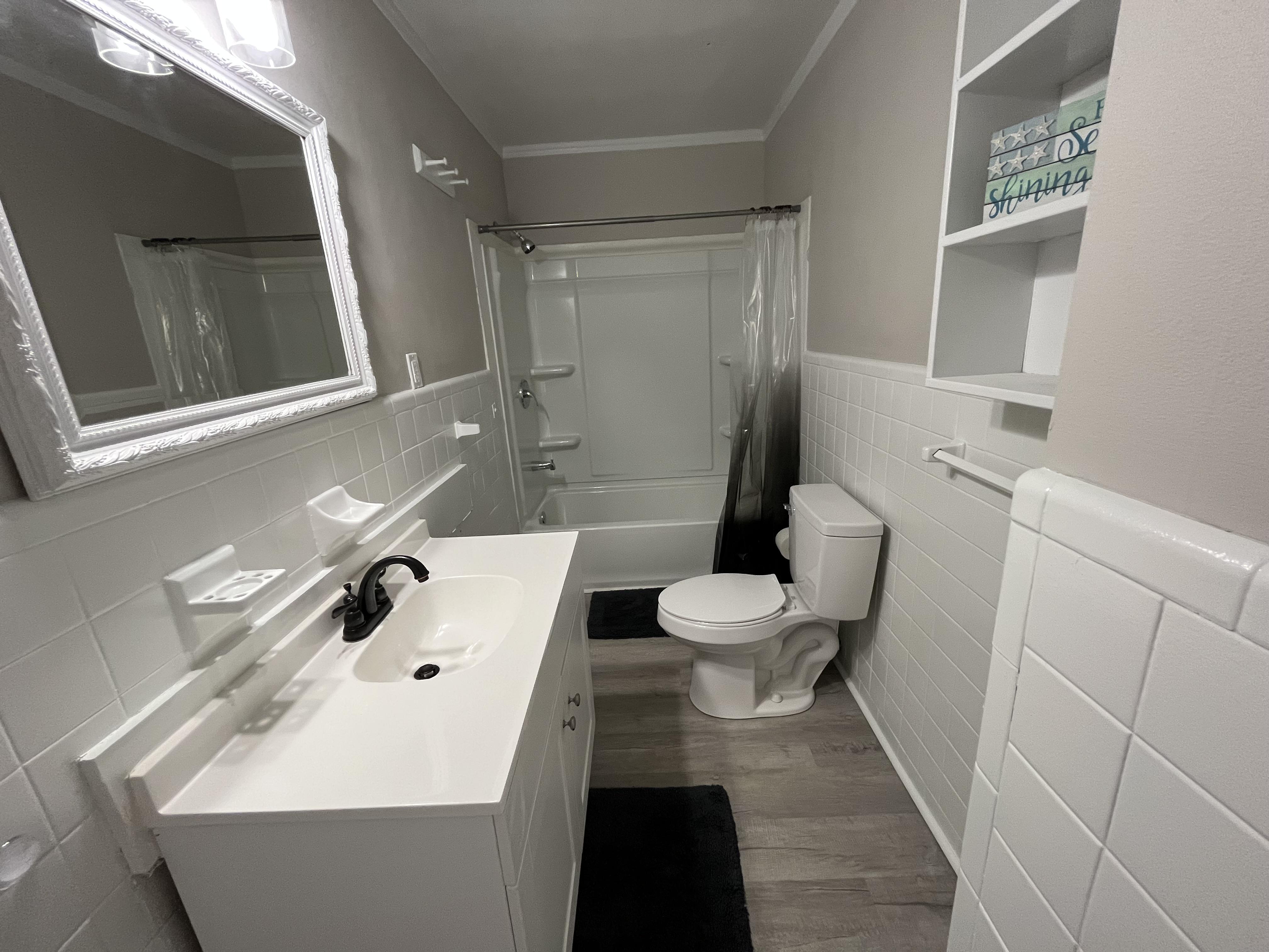 Sparkling clean bathroom with extra storage space and everything including shower is brand new!